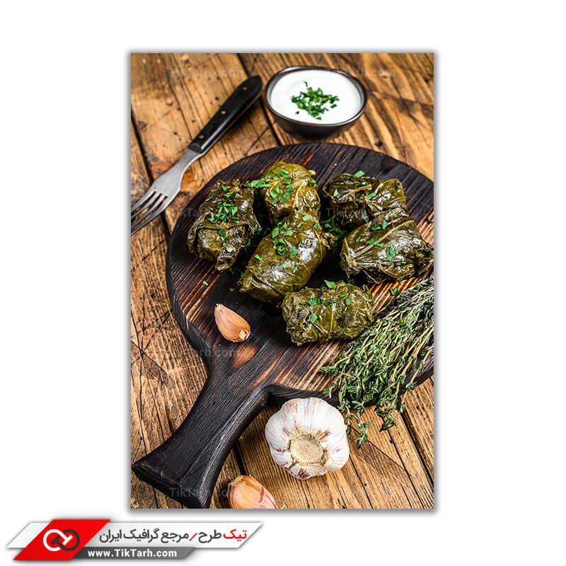 تصویر با کیفیت چند دلمه ی برگ انگور روی سینی چوبی