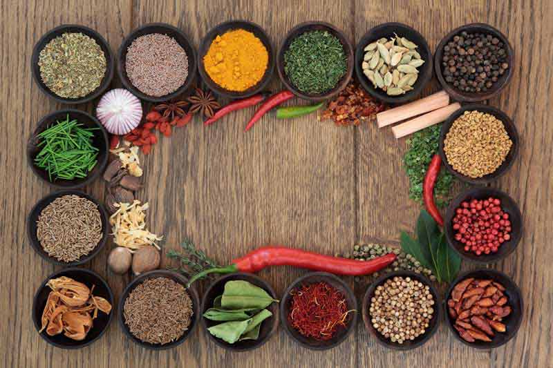 دانلود عکس با کیفیت ادویه جات داخل کاسه روی میز چوبی