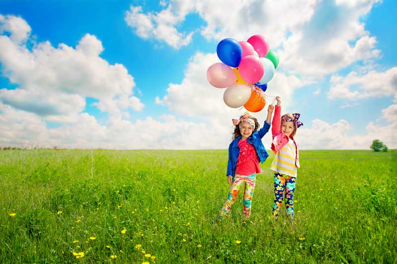 دانلود تصویر با کیفیت دو دختر در حال بازی با بادکنک های رنگی